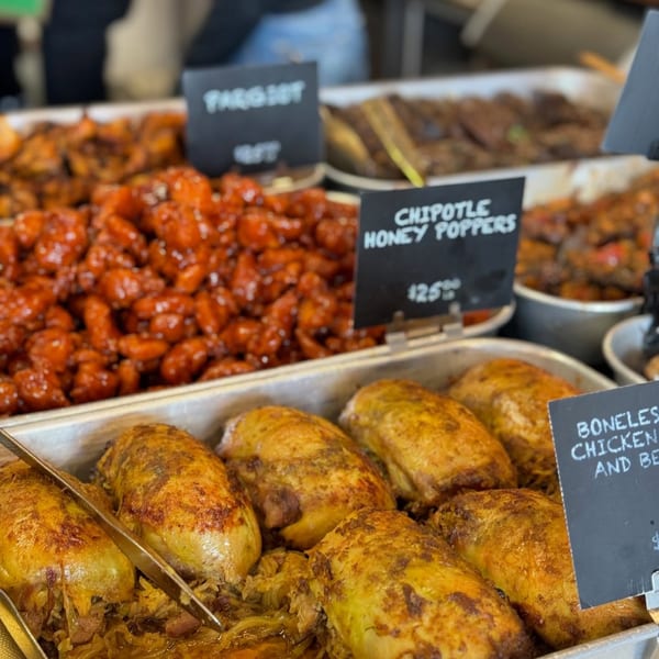 Trays of Chipotle Honey Poppers and boneless chicken and beef dishes at a buffet.